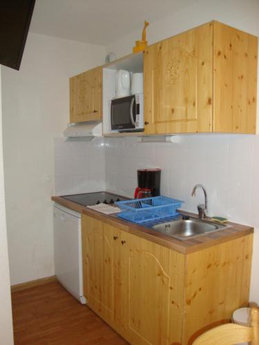 uma pequena cozinha com um lavatório e um micro-ondas em Orelle 3 Vallées - 2 pièces 5 personnes em Orelle