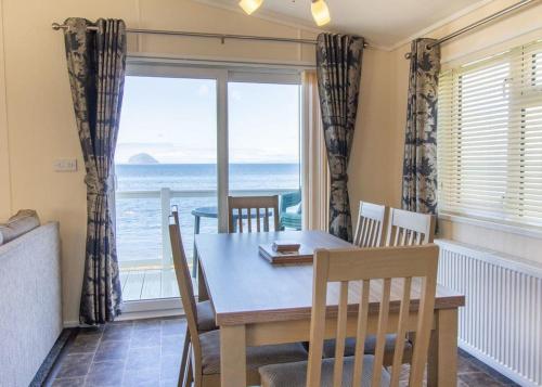 a dining room with a table and a view of the ocean at Bennane Shore Holiday Park in Lendalfoot