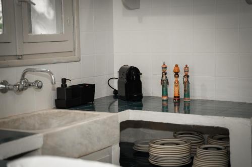 a kitchen with a counter top with plates and a sink at Dimoulitsa Villas Complex in Doukádes