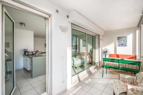 un salon avec un banc vert et une cuisine dans l'établissement Appartement California - Welkeys, à Nice
