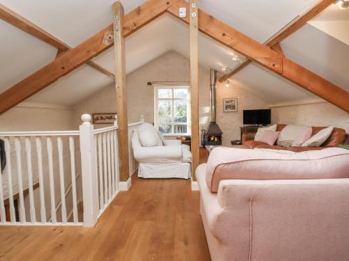 a attic room with two beds and a couch at The Old Barn in Colyton