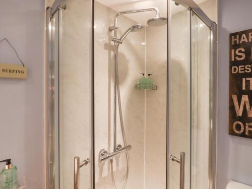 a shower with a glass door in a bathroom at The Old Barn in Colyton