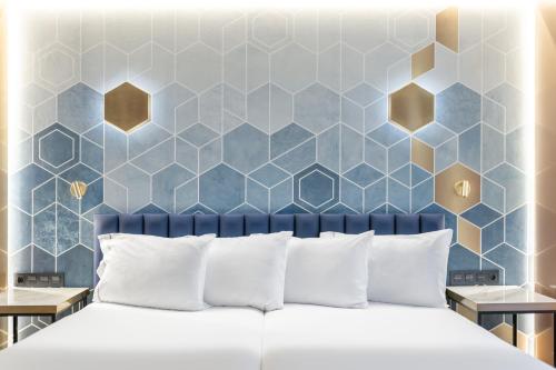 a bedroom with a blue and gold hexagonal wall at Eurostars Gran Madrid in Alcobendas