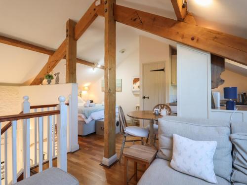a living room with a couch and a table at The Hay Loft in Colyton