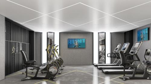 a gym with a row of treadmills and exercise machines at Holiday Inn & Suites - Al Khobar by IHG in Al Khobar