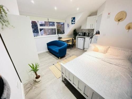 a bedroom with a large bed and a blue chair at Hackney Studios by Sleepy in London