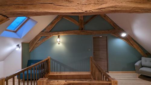 an attic with wooden beams and a stairway at La Ferme du Château in Beire-le-Châtel