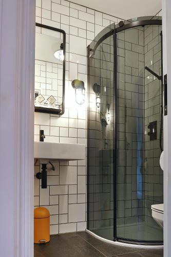 a bathroom with a glass shower and a sink at The Brownswood in London
