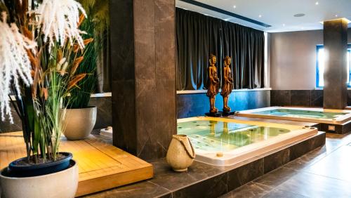 a jacuzzi tub in a lobby with plants at Hotel Up Wellness & Spa in Foggia