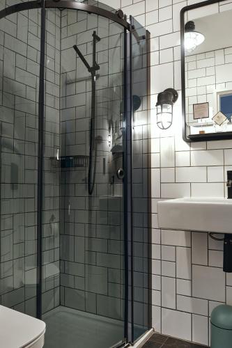 a glass shower in a bathroom with a sink at The Brownswood in London