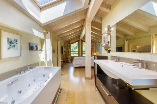 une grande salle de bains avec deux lavabos et une grande fenêtre dans l'établissement Chalet Galadhrim Chamonix Mont Blanc Valley, aux Houches