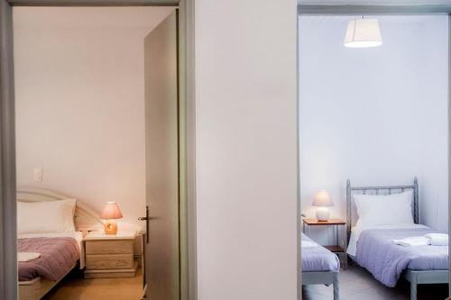 a bedroom with two beds and a mirror at angelikashouse,big house in Corfu Town