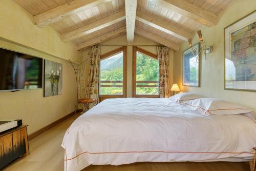 a bedroom with a large bed and a large window at Chalet Galadhrim Chamonix Mont Blanc Valley in Les Houches