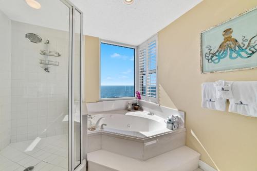 uma casa de banho com uma banheira, um lavatório e uma janela em Beach Colony East 13C em Perdido Key