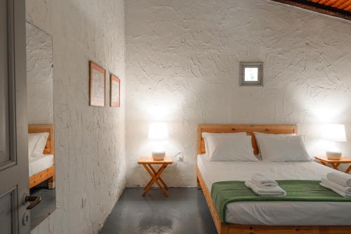 a bedroom with a bed and two tables with lamps at Dimoulitsa Villas Complex in Doukádes