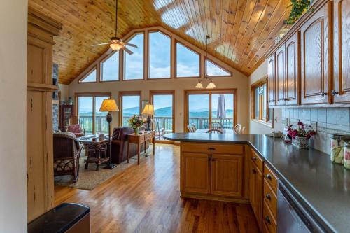 a large kitchen with wooden ceilings and a dining room at 1 Amazing View in Blowing Rock