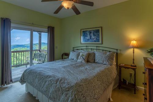 a bedroom with a bed with a view of a balcony at 1 Amazing View in Blowing Rock