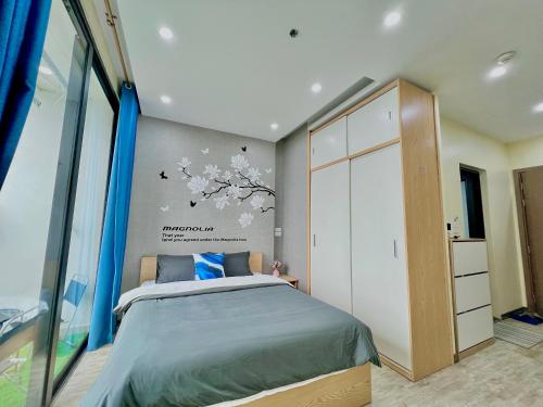 um quarto com uma cama e uma grande janela em Layla House -2905 G3 Vinhomes Greenbay em Hanói