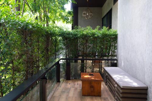 a balcony with a bench and a table on it at La Miniera Pool Villas Pattaya - SHA Plus in Nong Prue