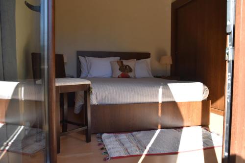 - une chambre avec un lit et un chat assis dans l'établissement Alvão Village & Camping, 