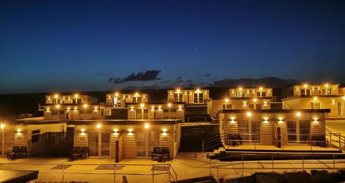 um grupo de edifícios com luzes à noite em Aran Islands Hotel em Kilronan