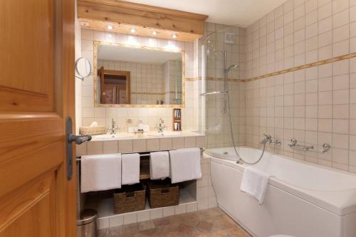 La salle de bains est pourvue d'une baignoire, d'un lavabo et d'un miroir. dans l'établissement Le Chalet de Flore, à Verbier