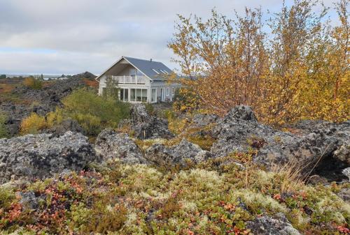 uma casa no topo de uma colina com pedras em Slow Travel Mývatn - Þúfa - Private Homestay em Myvatn