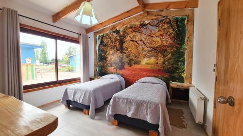 two beds in a room with a painting on the wall at Alto Maquehue in Padre Las Casas