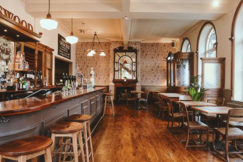 a bar with wooden tables and chairs in a restaurant at The Brownswood in London