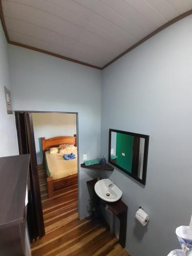 a bathroom with a sink and a mirror and a bed at Bungalow Batsù in Fortuna