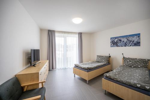 ein Hotelzimmer mit 2 Betten und einem Schreibtisch in der Unterkunft Kästle Residence in Nové Město na Moravě