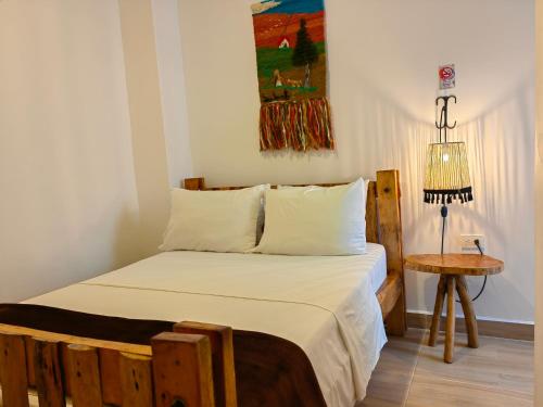 a bedroom with a bed and a table and a painting at Hotel Salento Mirador in Salento