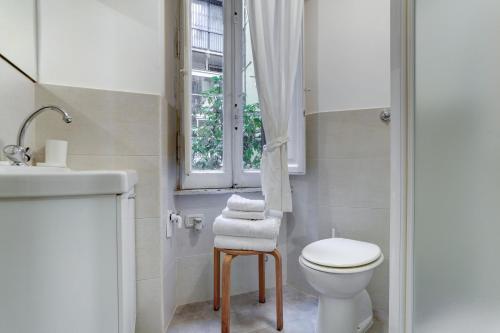 een badkamer met een toilet, een wastafel en een raam bij Charming Colosseum in Rome