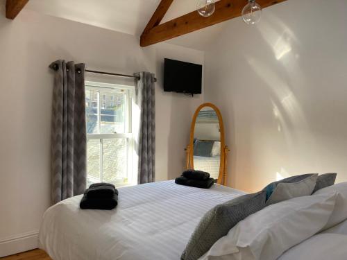 1 dormitorio con cama, espejo y ventana en Finest Retreats - Backlet Cottage - Mevagissey Cottage Sleeps 4, en Mevagissey