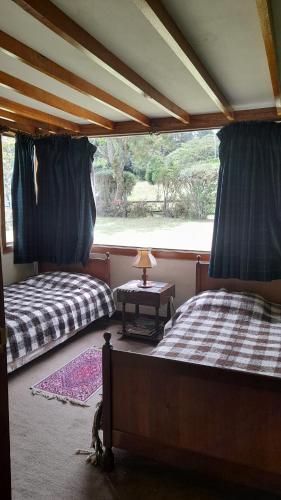 two beds in a room with a window at La finca del Abuelo in Fúquene