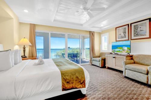 ein Schlafzimmer mit einem großen Bett und einem Balkon in der Unterkunft Dove Creek Resort & Marina, Trademark Collection by Wyndham in Key Largo