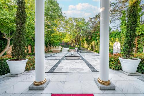 einen Garten mit weißen Säulen und einem Brunnen in der Unterkunft Bosphorus Palace Hotel in Istanbul
