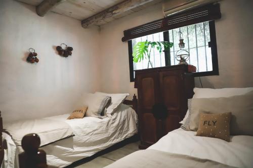 2 Einzelbetten in einem Zimmer mit Fenster in der Unterkunft Campo de los Sueños in Colonia del Sacramento