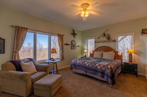een slaapkamer met een bed, een stoel en een raam bij A Bears Eye View in Blowing Rock