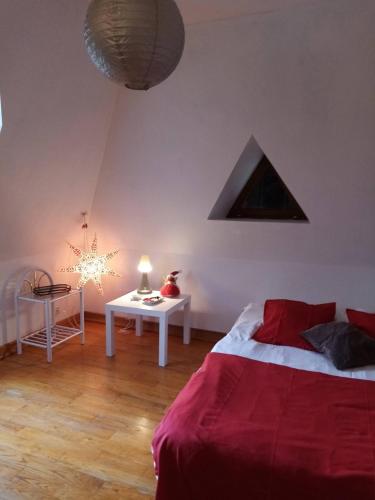 1 dormitorio con 1 cama y 1 mesa con lámpara en Longère les pieds dans l eau, en Saint-Philbert-sur-Risle