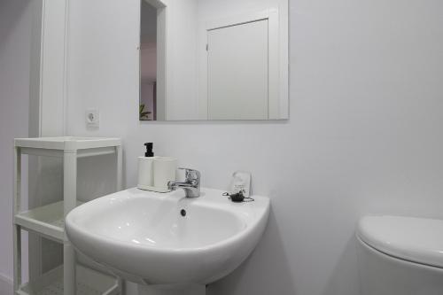 een witte badkamer met een wastafel en een toilet bij La Maruca Beach Santander in Santander