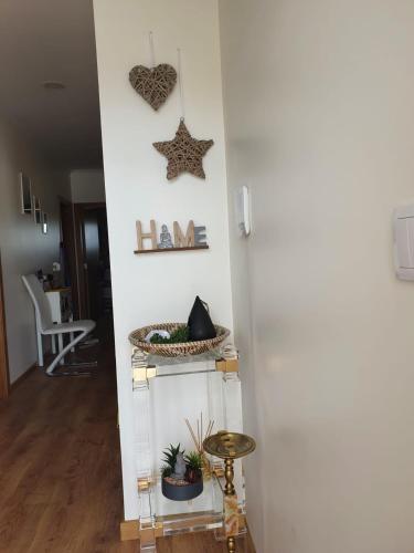 a room with a white wall with a shelf with plants at Alojamento Local Terreiro in Pombal