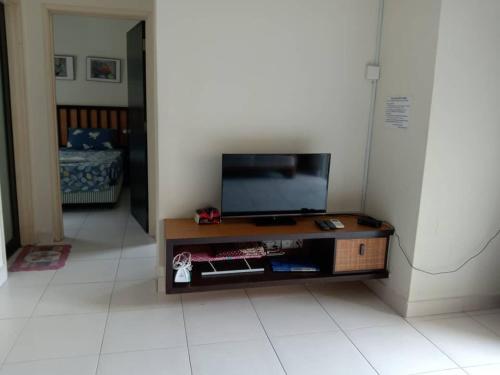 a living room with a flat screen tv on a table at ZamLan Gold Coast Morib Intl Resort - 3 Rooms Apartment in Banting