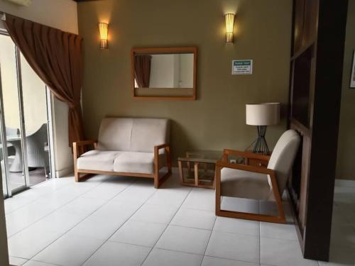 a living room with a chair and a mirror at ZamLan Gold Coast Morib Intl Resort - 3 Rooms Apartment in Banting
