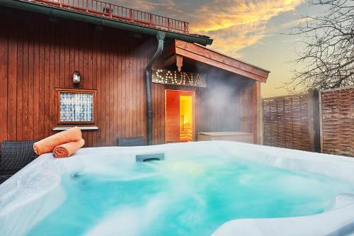 a hot tub in front of a building at Chiemgauferienwohnungen - Wanderlust und Alpenrose in Unterwössen