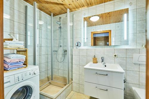 y baño con ducha y lavadora. en Chiemgauferienwohnungen - Wanderlust und Alpenrose, en Unterwossen