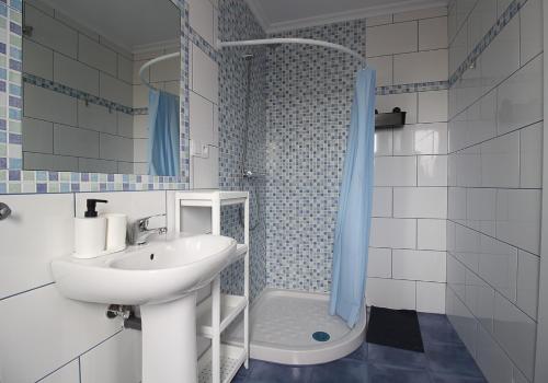 y baño blanco con lavabo y ducha. en loft con office santander en Santander