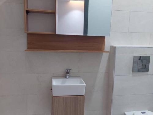 a bathroom with a white sink and a toilet at Harbor Pond Apartments 2 in Lagos