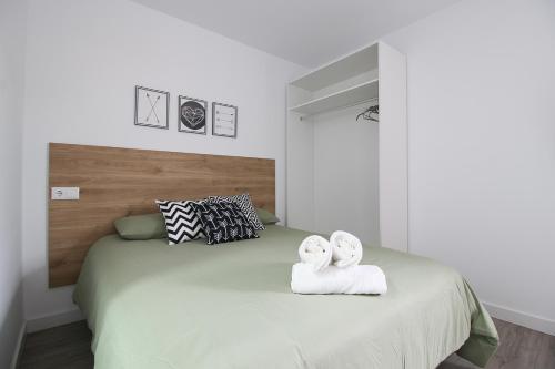 1 dormitorio con 1 cama con toallas en La maruca loft, en Santander