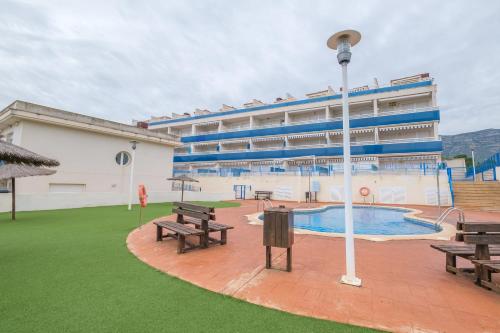 a large building with a pool and benches in front of it at Apartamento Merida in Alcanar